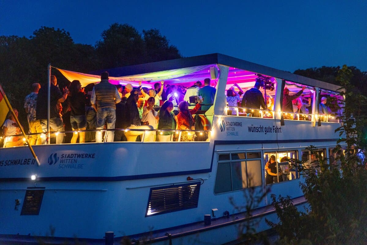 Personen bei Dunkelheit an Deck der beleuchteten Schwalbe